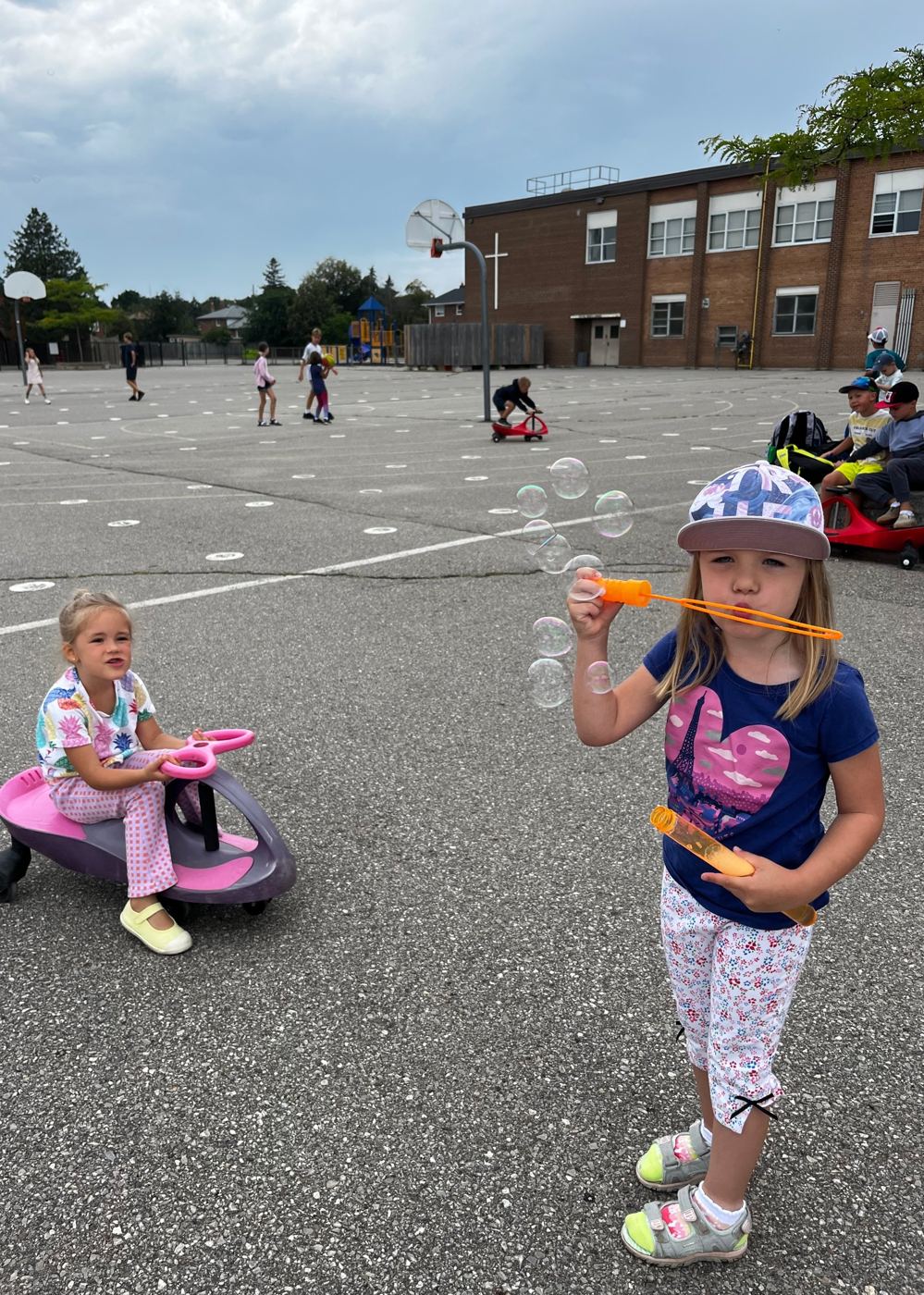 A camper blowing bubbles in the schoolyard